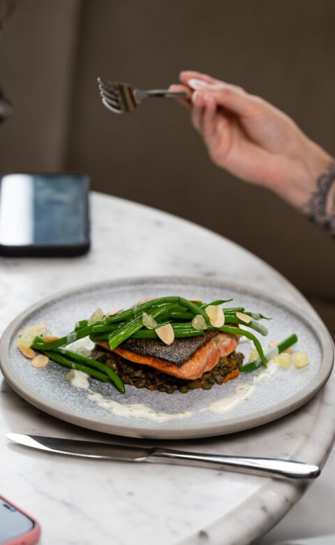 a close up photo of a pan seared salmon entree dish at a restaurant