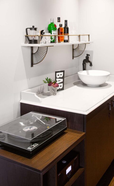 record player on table with countertop and bowl shaped sink beside it