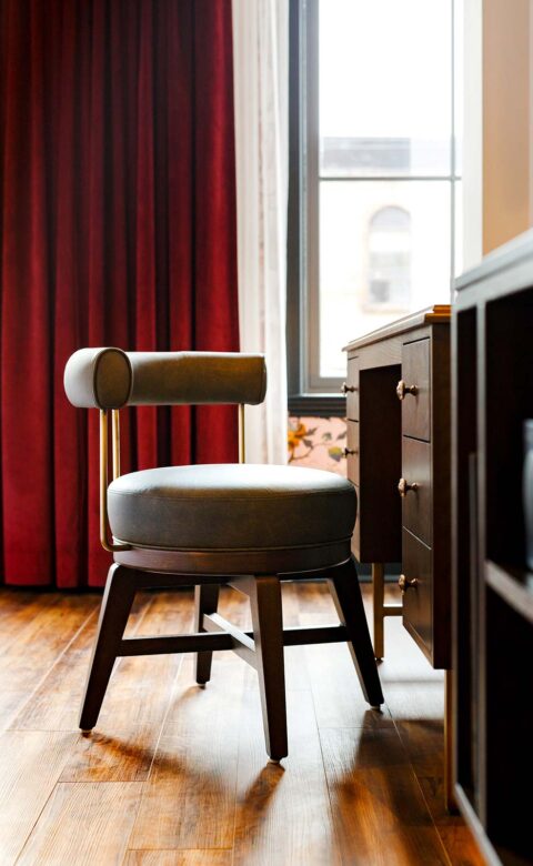 round leather chair sitting in front of wooden desk