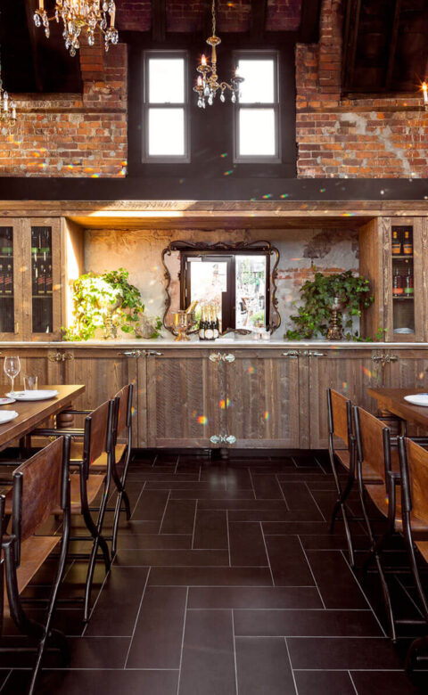event space with set wooden tables on the left and right and cabinetry in the background