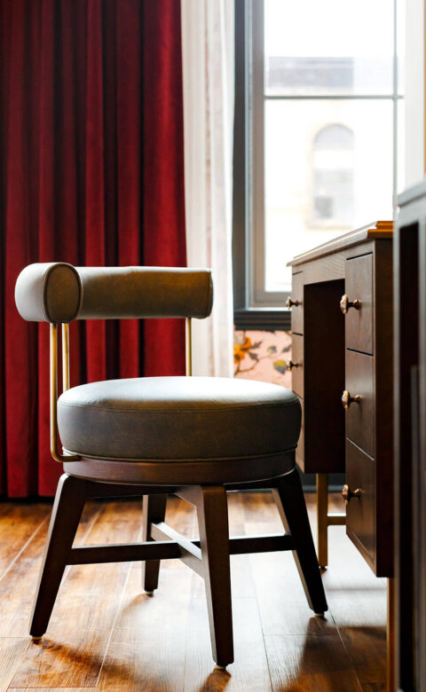 round leather chair sitting in front of wooden desk