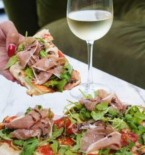 a woman taking a slice of pizza