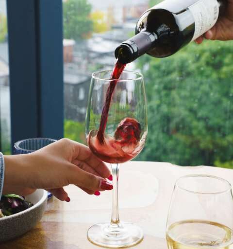 a glass of red wine being poured