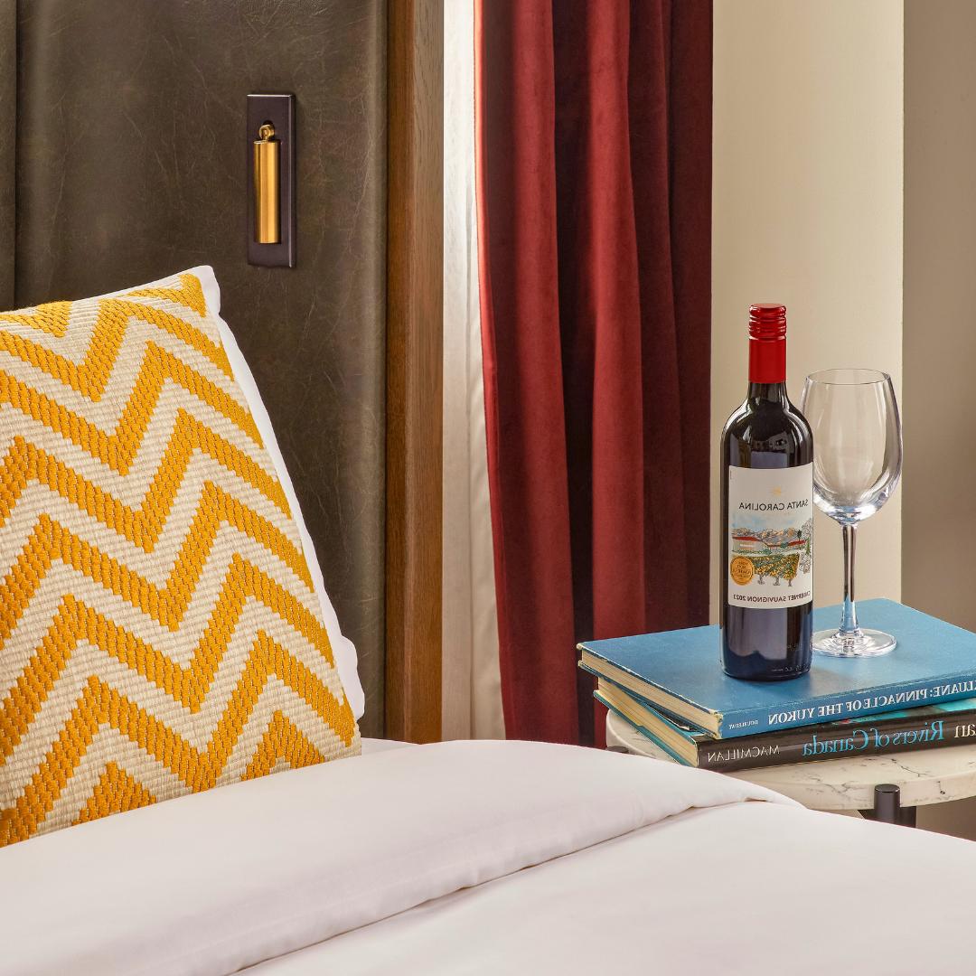 Wine bottle kept on table next to bed