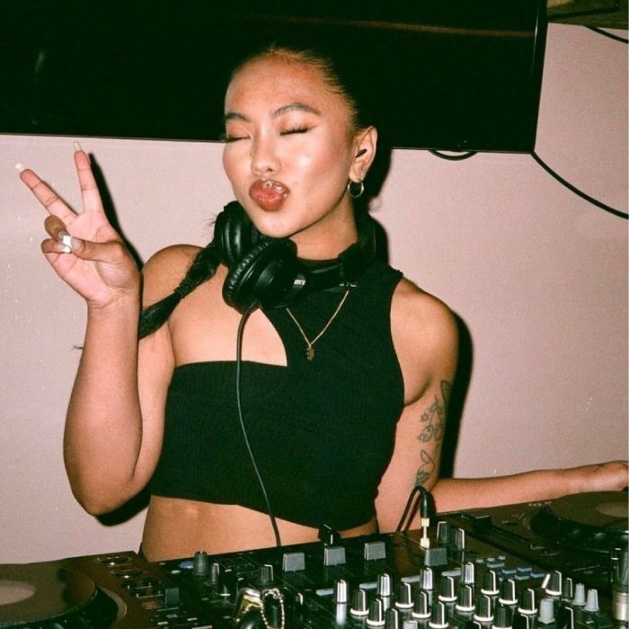 a woman wearing headphones and making a peace sign