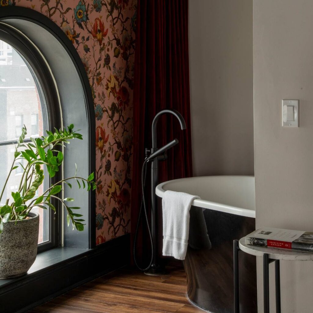a bath tub next to a window in a bathroom