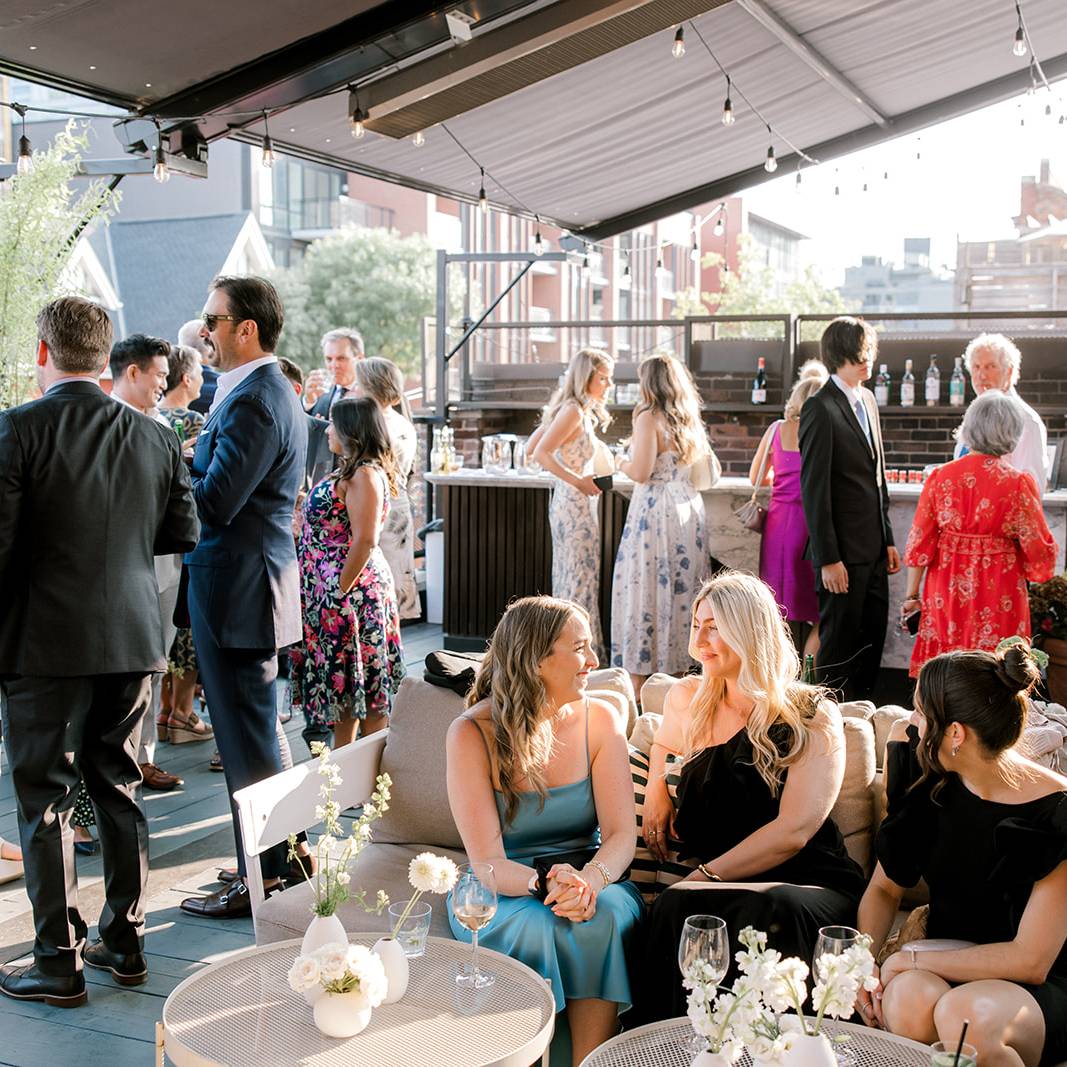 a group of people at a function under a pergola