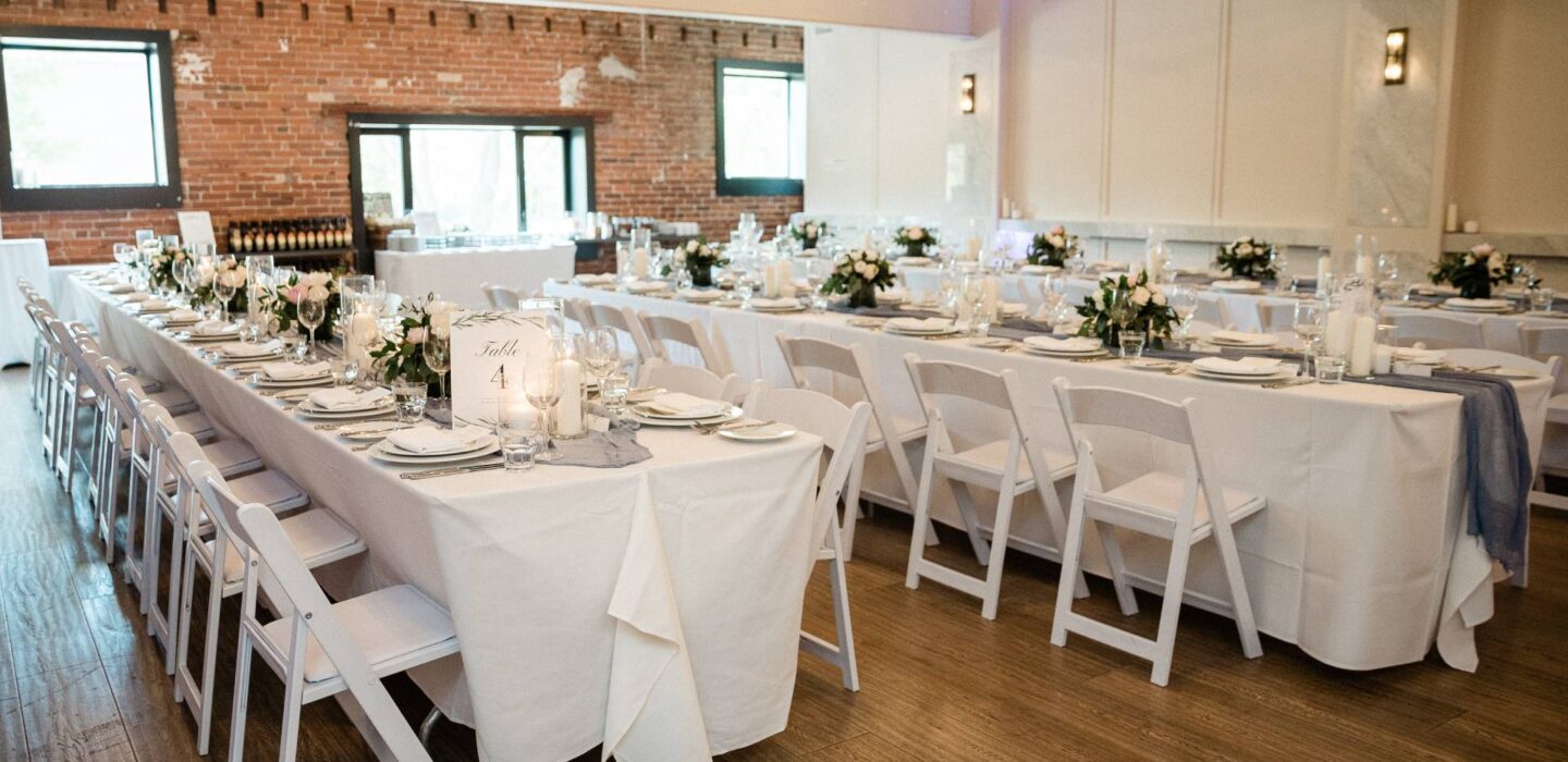Formal dining table setup in an event space with exposed brick walls.