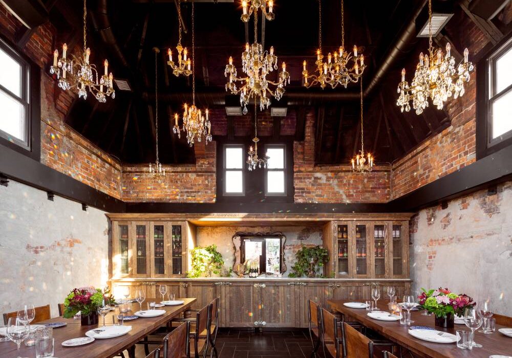 Private dining setup featuring long wooden tables, floral centerpieces, and ornate chandeliers.