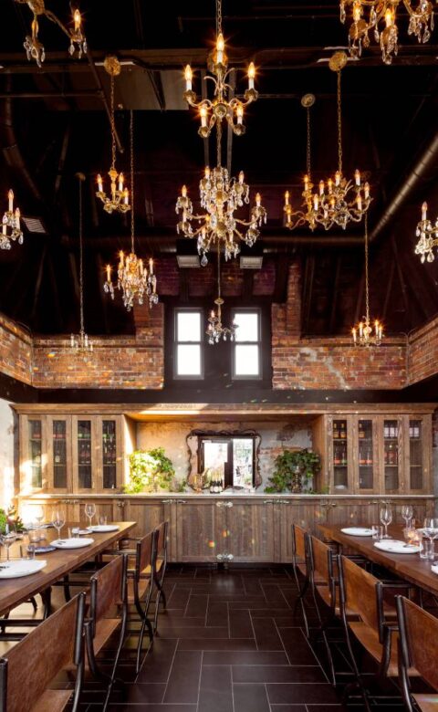 Private dining setup featuring long wooden tables, floral centerpieces, and ornate chandeliers.