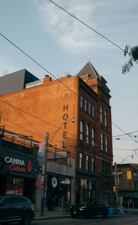 Exterior of The Broadview Hotel brick building with streetcars wires and storefronts along the street.